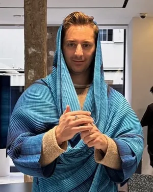 Adrian in blue outfit resembling Dune aesthetics