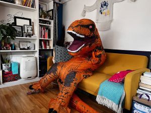 Adrian in a T-Rex costume working from home
